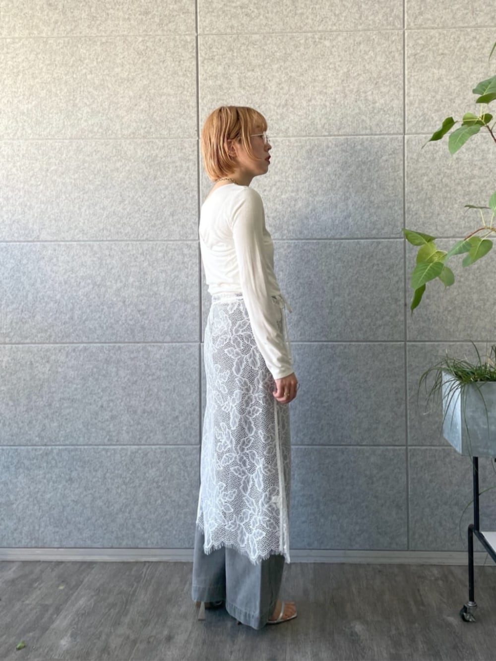 グレー系のデニムパンツ、ホワイト系のTシャツ/カットソー、ホワイト系のスカートを着用したレディースの春コーディネートの2枚目の写真