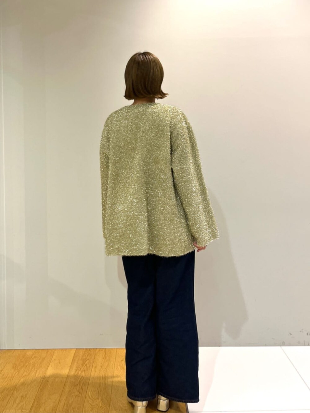 ブルー系のデニムパンツ、ベージュ系のTシャツ/カットソー、ゴールド系のカーディガン/ボレロを着用したレディースの秋コーディネートの2枚目の写真