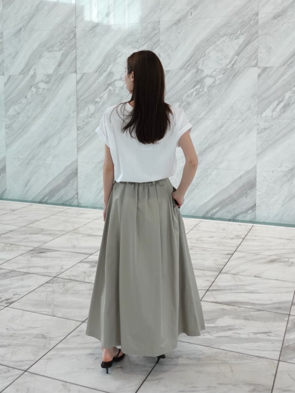 グリーン系のスカート、ホワイト系のTシャツ/カットソーを着用したレディースの春コーディネートの3枚目の写真