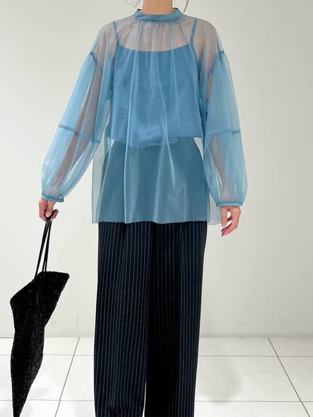 ブラック系のトートバッグ、ブルー系のシャツ/ブラウス、ブラック系のその他パンツを着用したレディースの秋コーディネートの2枚目の写真