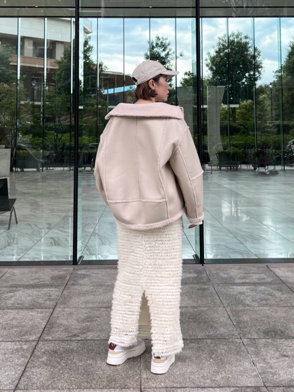 ホワイト系のスカート、ホワイト系のブルゾン、ホワイト系のTシャツ/カットソーを着用したレディースの秋コーディネートの3枚目の写真