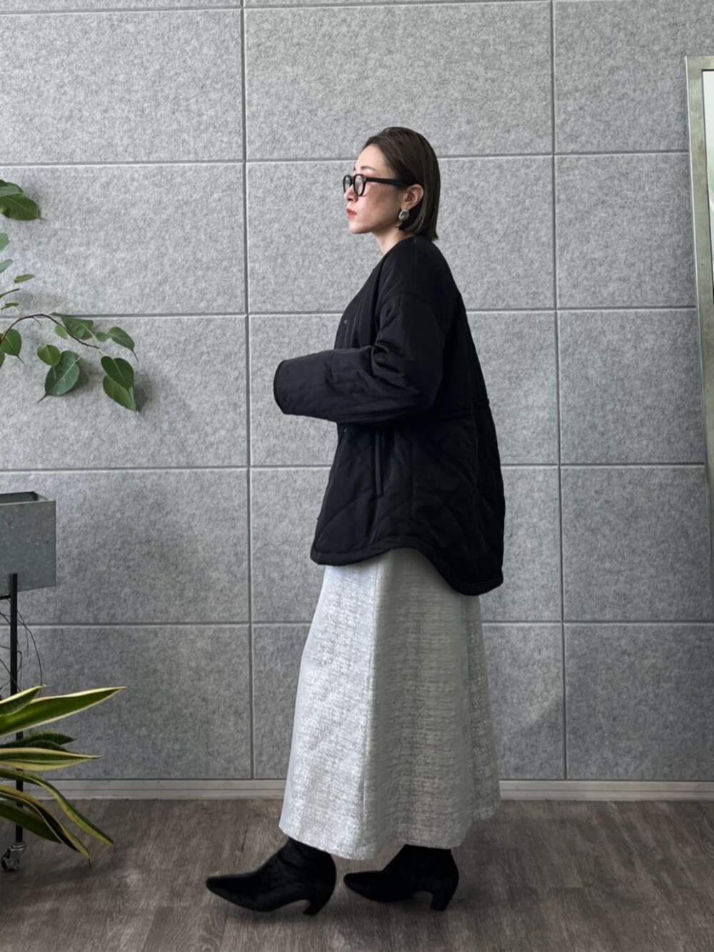 ブラック系のブーツ、ブラック系のその他アウター、グレー系のスカートを着用したレディースの冬コーディネートの3枚目の写真