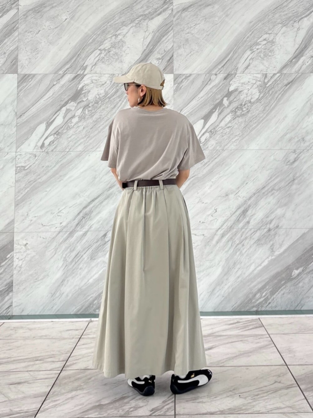 グリーン系のスカート、グレー系のTシャツ/カットソーを着用したレディースの春コーディネートの4枚目の写真