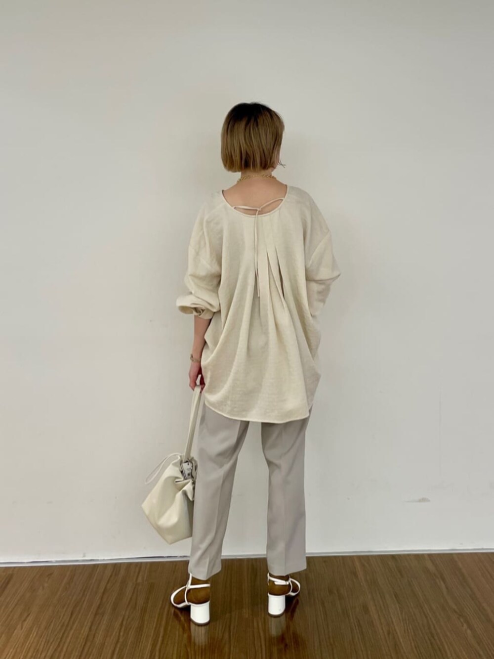 ホワイト系のシャツ/ブラウス、ベージュ系のその他パンツ、ゴールド系のネックレスを着用したレディースの秋コーディネートの2枚目の写真