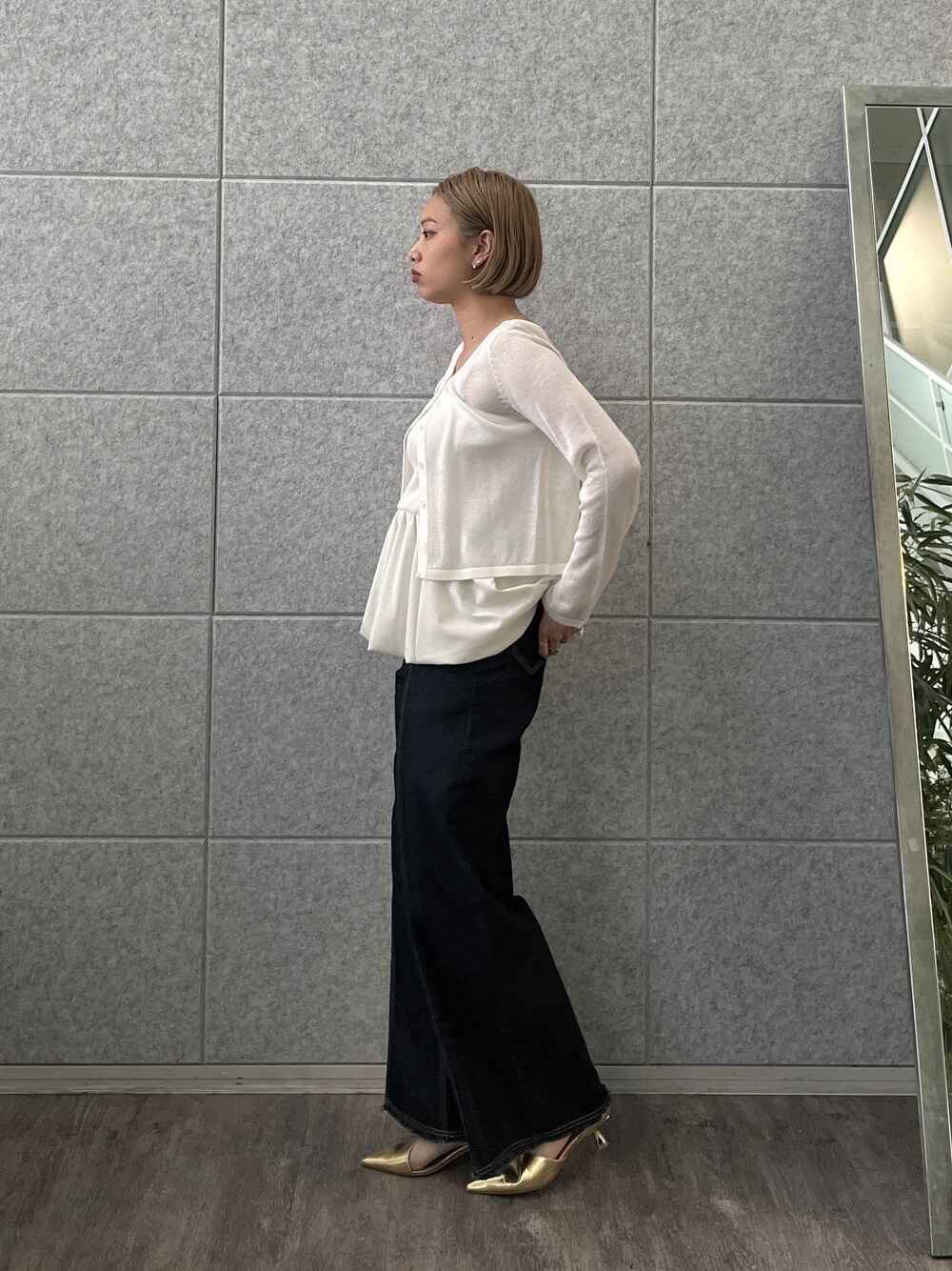 ブルー系のデニムパンツ、ホワイト系のアンサンブルを着用したレディースの春コーディネートの3枚目の写真
