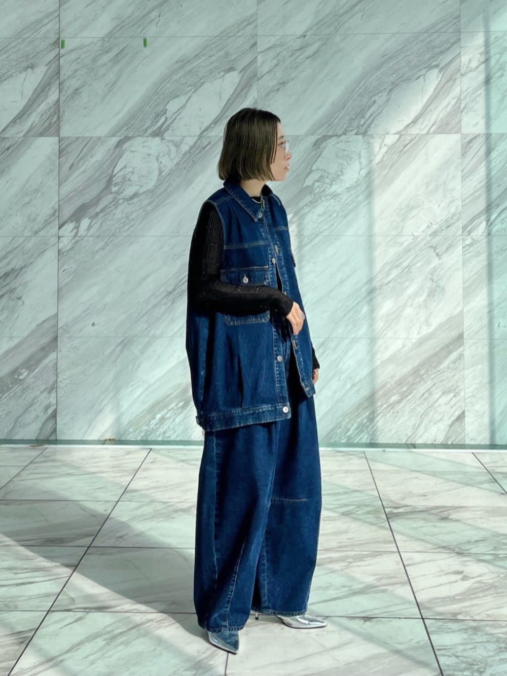 ブルー系のデニムパンツ、ブルー系のデニムジャケット、ブラック系のニット/セーターを着用したレディースの冬コーディネートの2枚目の写真