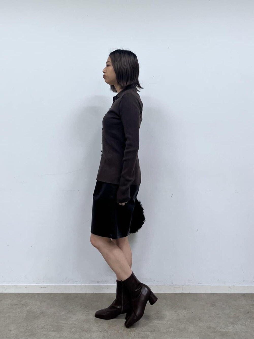 ブラウン系のニット/セーター、ブラック系のその他パンツ、ブラック系のブーツを着用したレディースの秋コーディネートの3枚目の写真