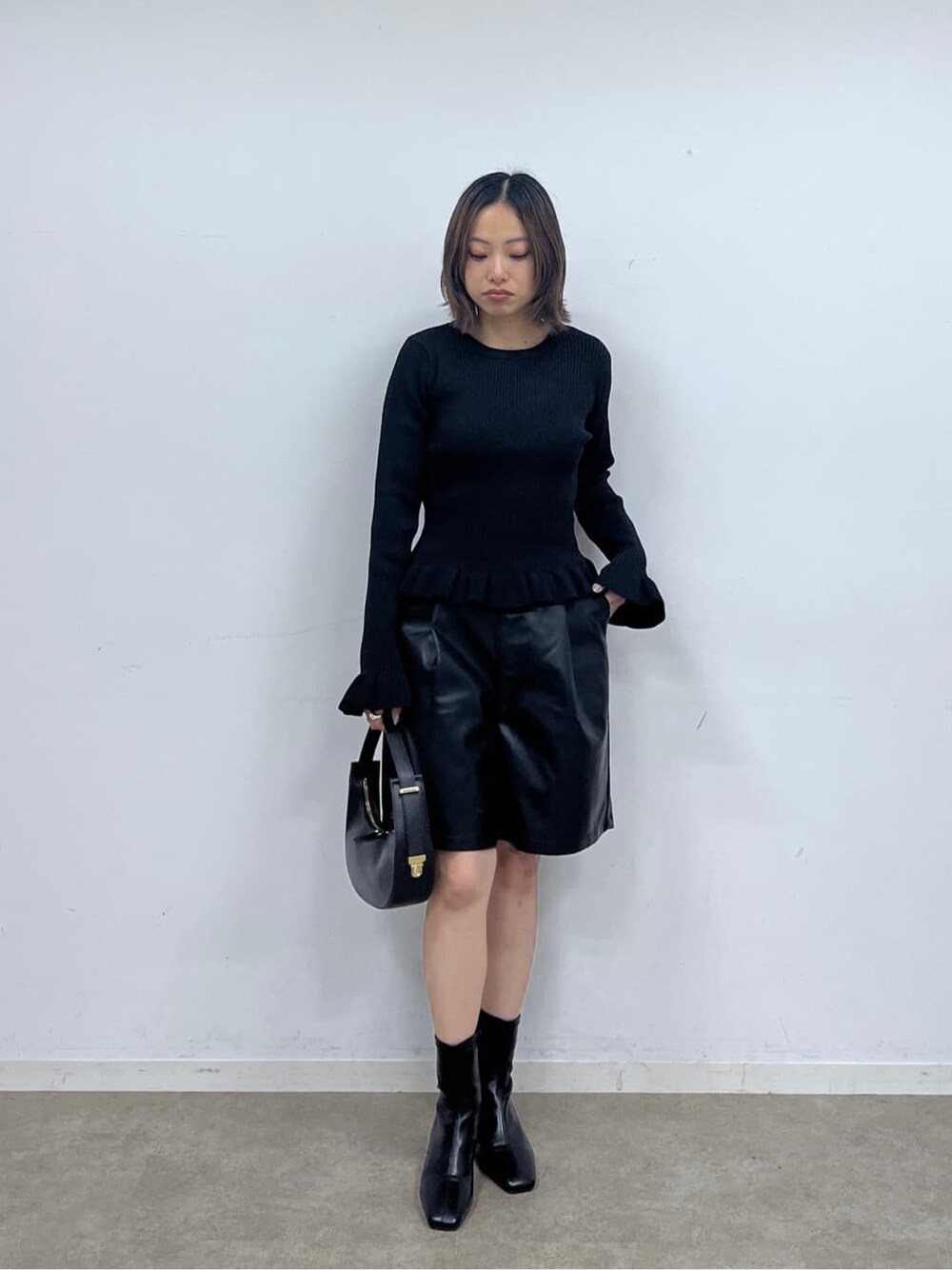 ブラック系のニット/セーター、ブラック系のその他パンツ、ブラック系のハンドバッグを着用したレディースの秋コーディネートの2枚目の写真