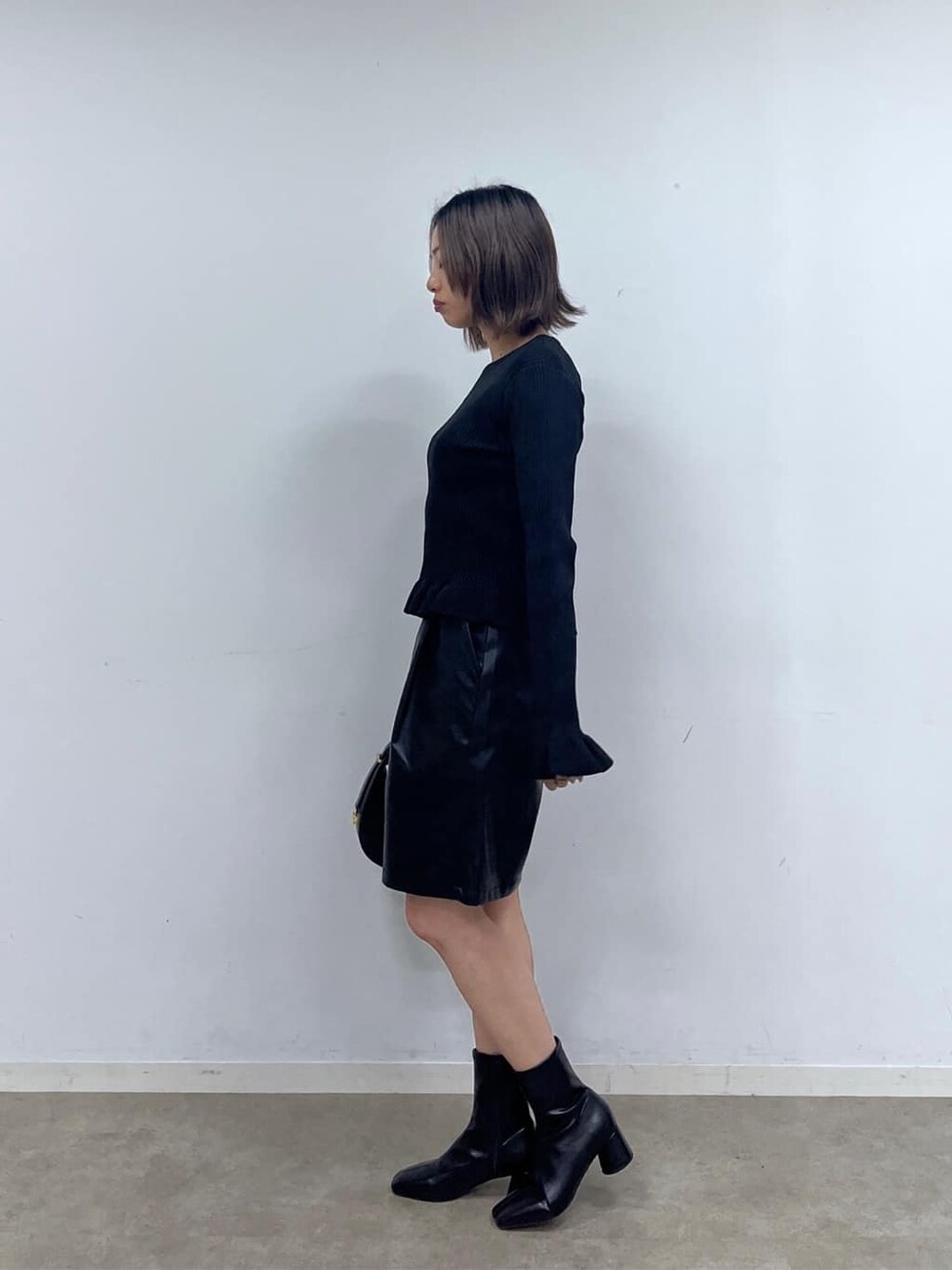 ブラック系のニット/セーター、ブラック系のその他パンツ、ブラック系のハンドバッグを着用したレディースの秋コーディネートの3枚目の写真