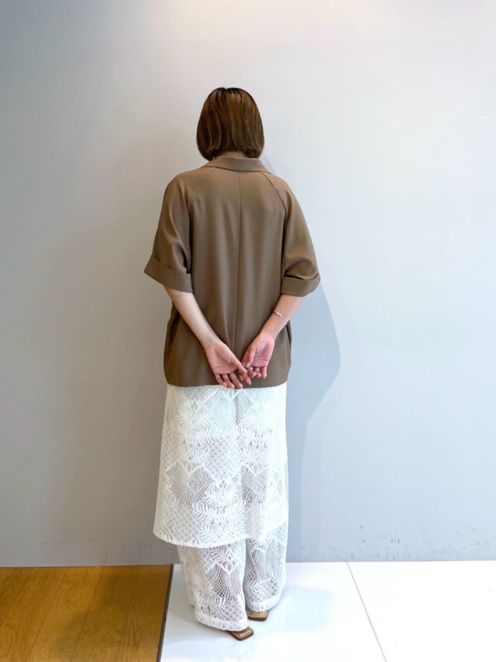 イエロー系のテーラードジャケットを着用したレディースの春コーディネートの2枚目の写真