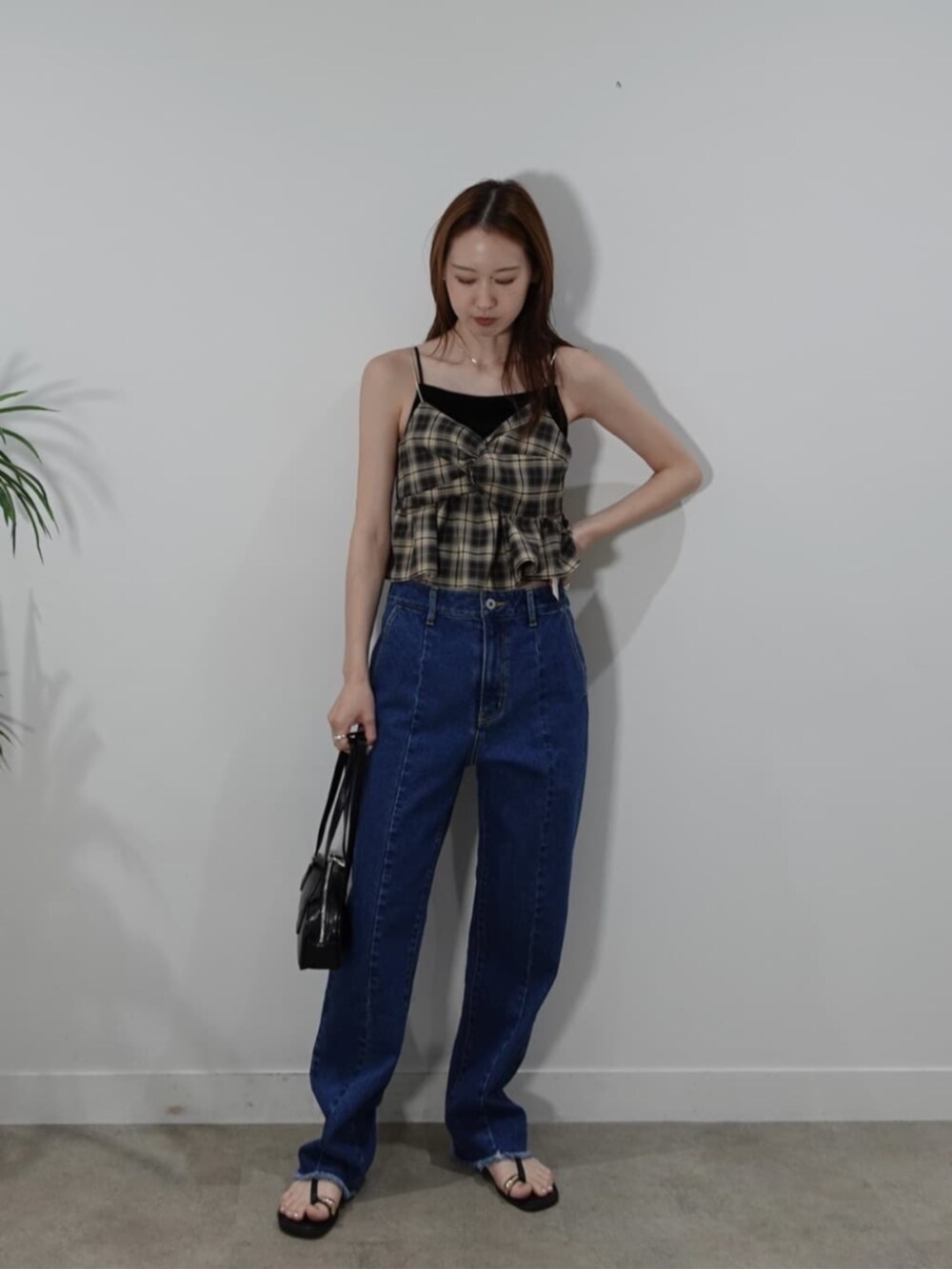 ブルー系のデニムパンツ、ベージュ系のタンクトップを着用したレディースの夏コーディネートの3枚目の写真