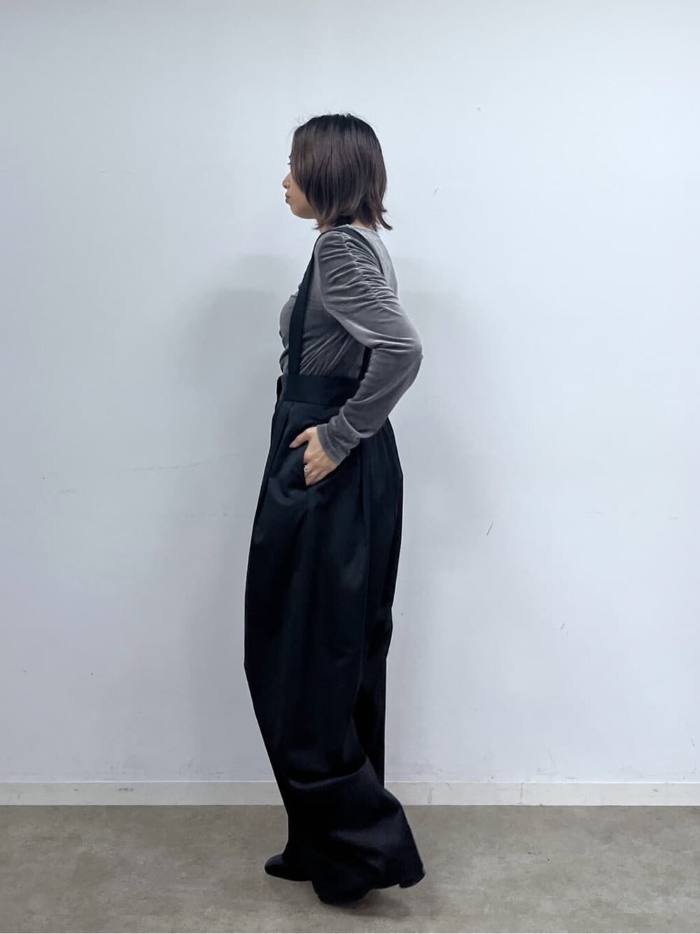 ブラック系のサロペット/オーバーオール、グレー系のTシャツ/カットソー、シルバー系のハンドバッグを着用したレディースの秋コーディネートの3枚目の写真