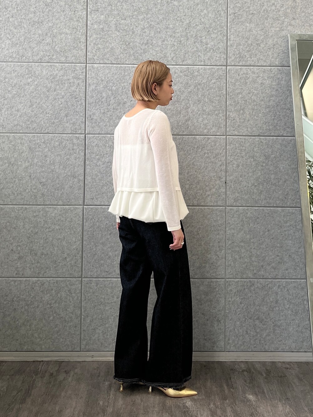 ブルー系のデニムパンツ、ホワイト系のアンサンブルを着用したレディースの春コーディネートの6枚目の写真