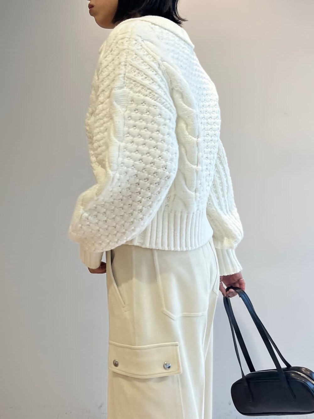 ホワイト系のニット/セーター、ホワイト系のその他パンツ、ブラック系のハンドバッグを着用したレディースの秋コーディネートの6枚目の写真