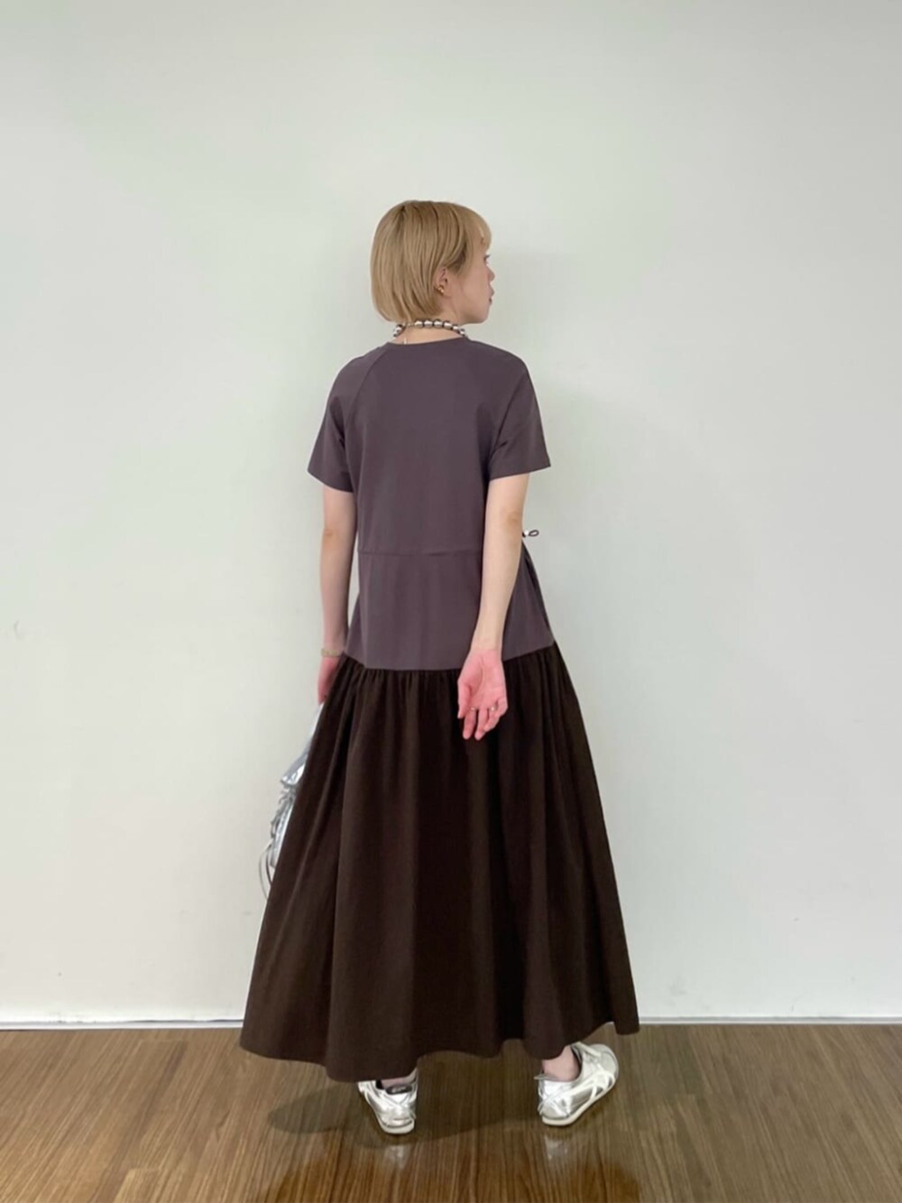 シルバー系のハンドバッグ、ブラウン系のワンピースを着用したレディースの春コーディネートの3枚目の写真