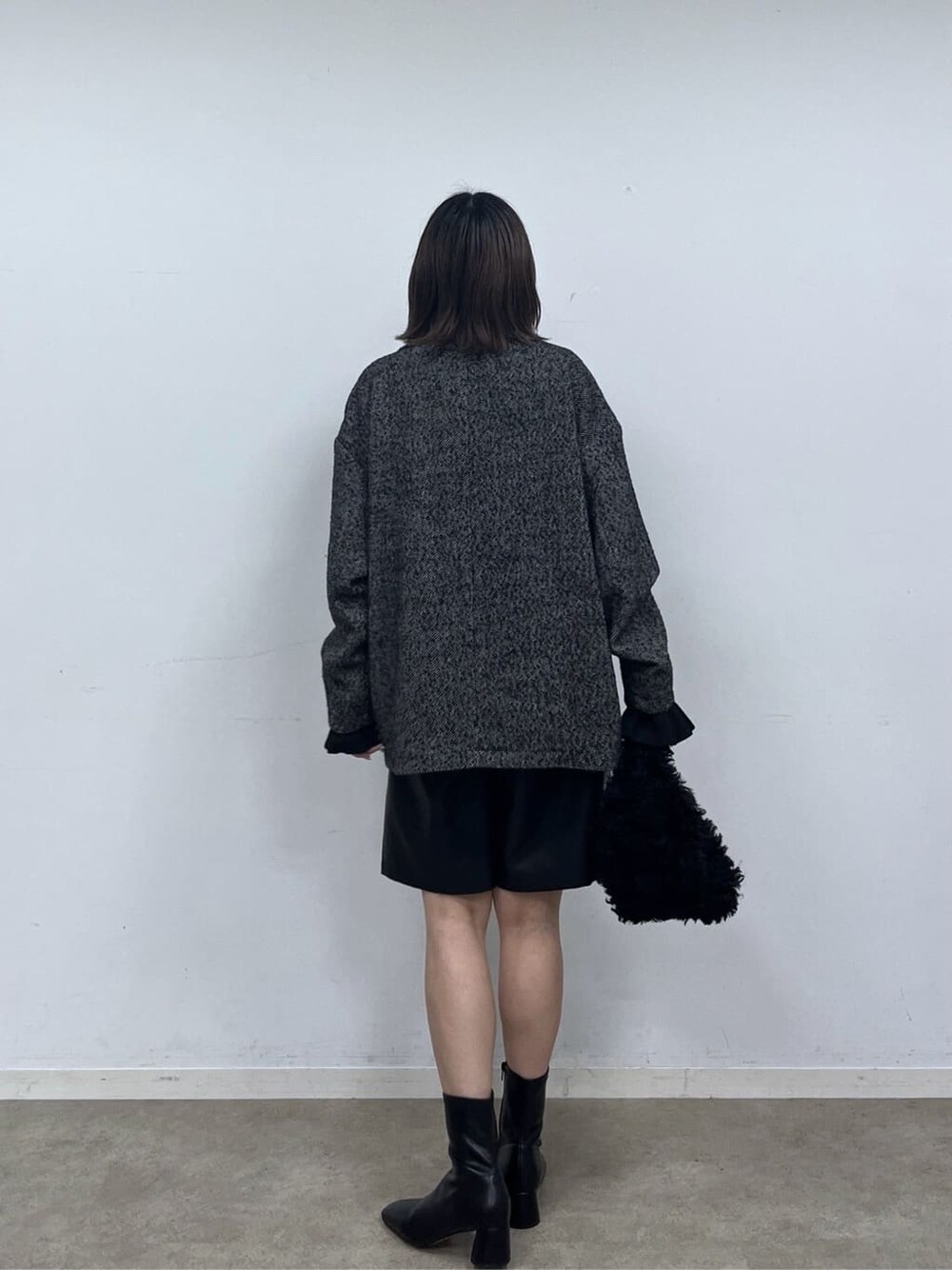 ブラック系のチェスターコート、ブラック系のニット/セーター、ブラック系のその他パンツを着用したレディースの秋コーディネートの5枚目の写真