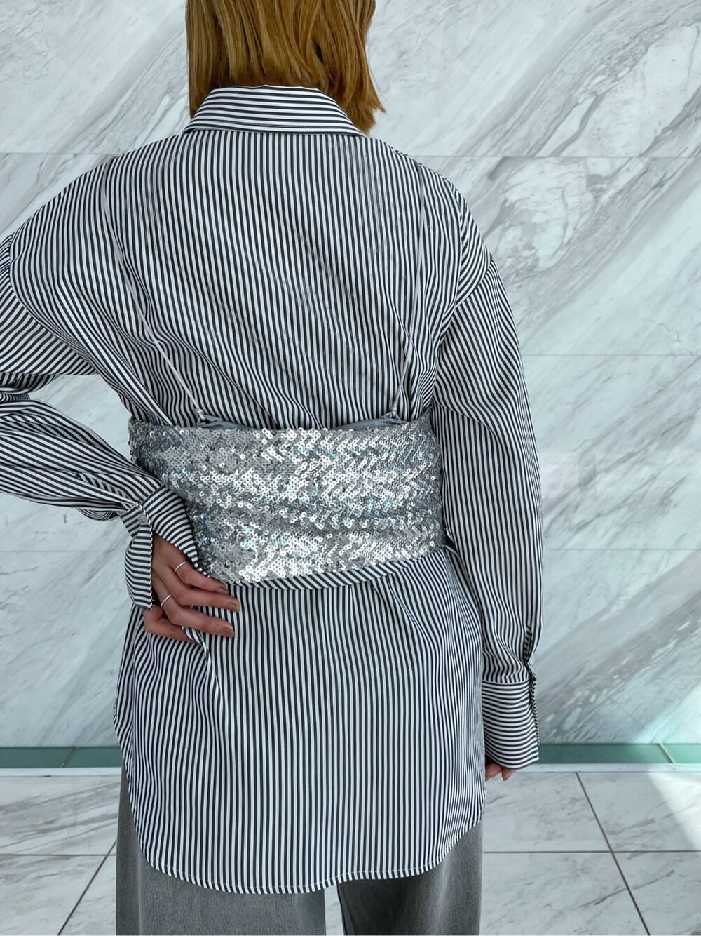 シルバー系のタンクトップ、ブラック系のシャツ/ブラウス、グレー系のデニムパンツを着用したレディースの冬コーディネートの6枚目の写真