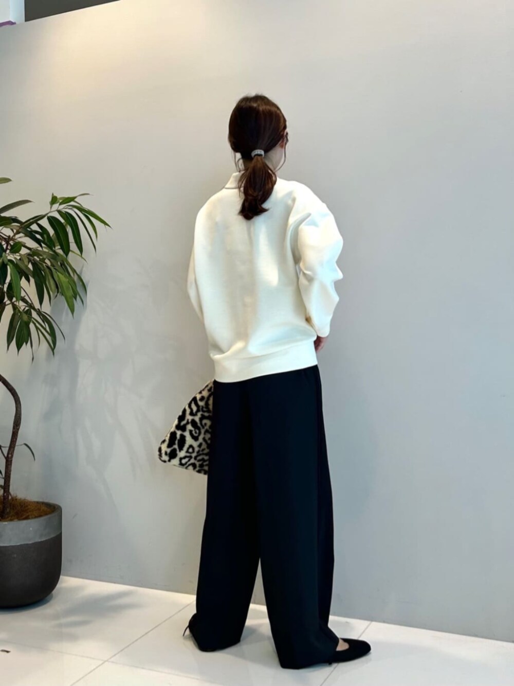 ブラウン系のハンドバッグ、ブラック系のその他パンツ、ホワイト系のTシャツ/カットソーを着用したレディースの秋コーディネートの2枚目の写真