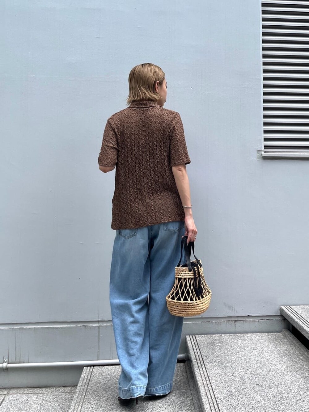 ブラウン系のシャツ/ブラウス、ブルー系のデニムパンツ、ブラック系のハンドバッグを着用したレディースの夏コーディネートの4枚目の写真