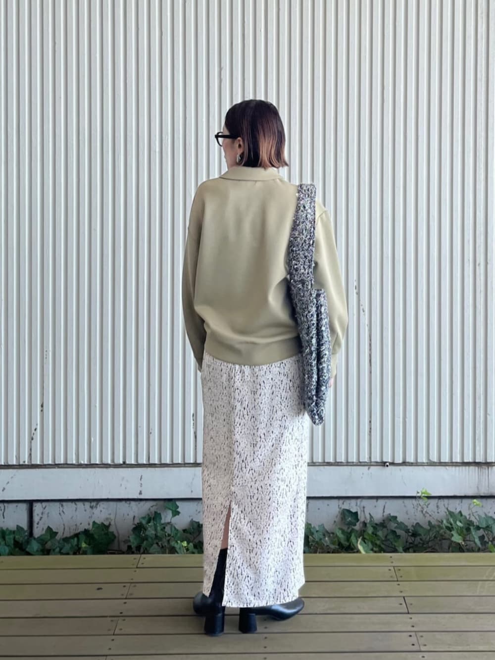 ホワイト系のスカート、シルバー系のトートバッグ、グリーン系のTシャツ/カットソーを着用したレディースの秋コーディネートの3枚目の写真