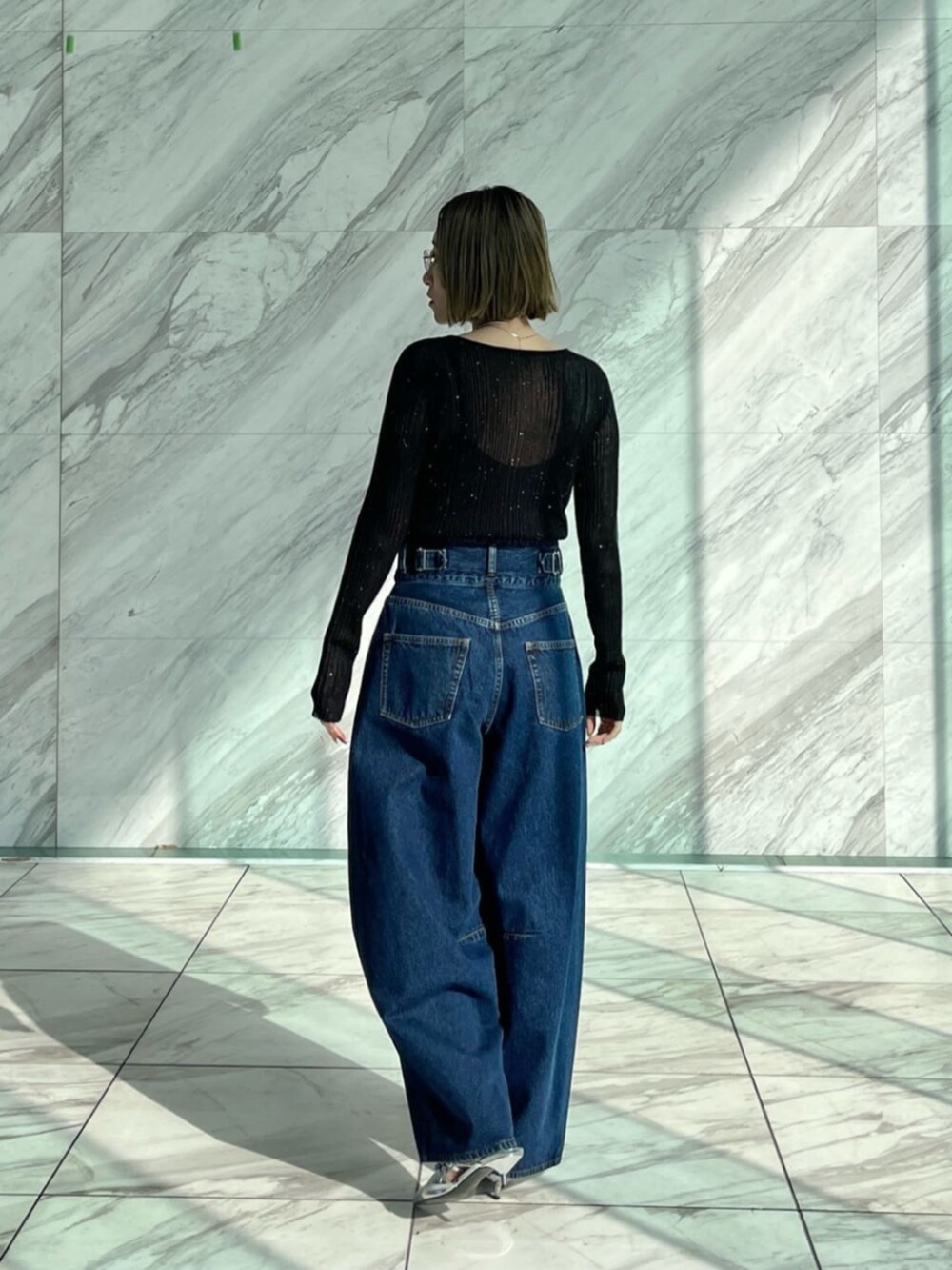 ブルー系のデニムパンツ、ブラック系のニット/セーターを着用したレディースの冬コーディネートの3枚目の写真