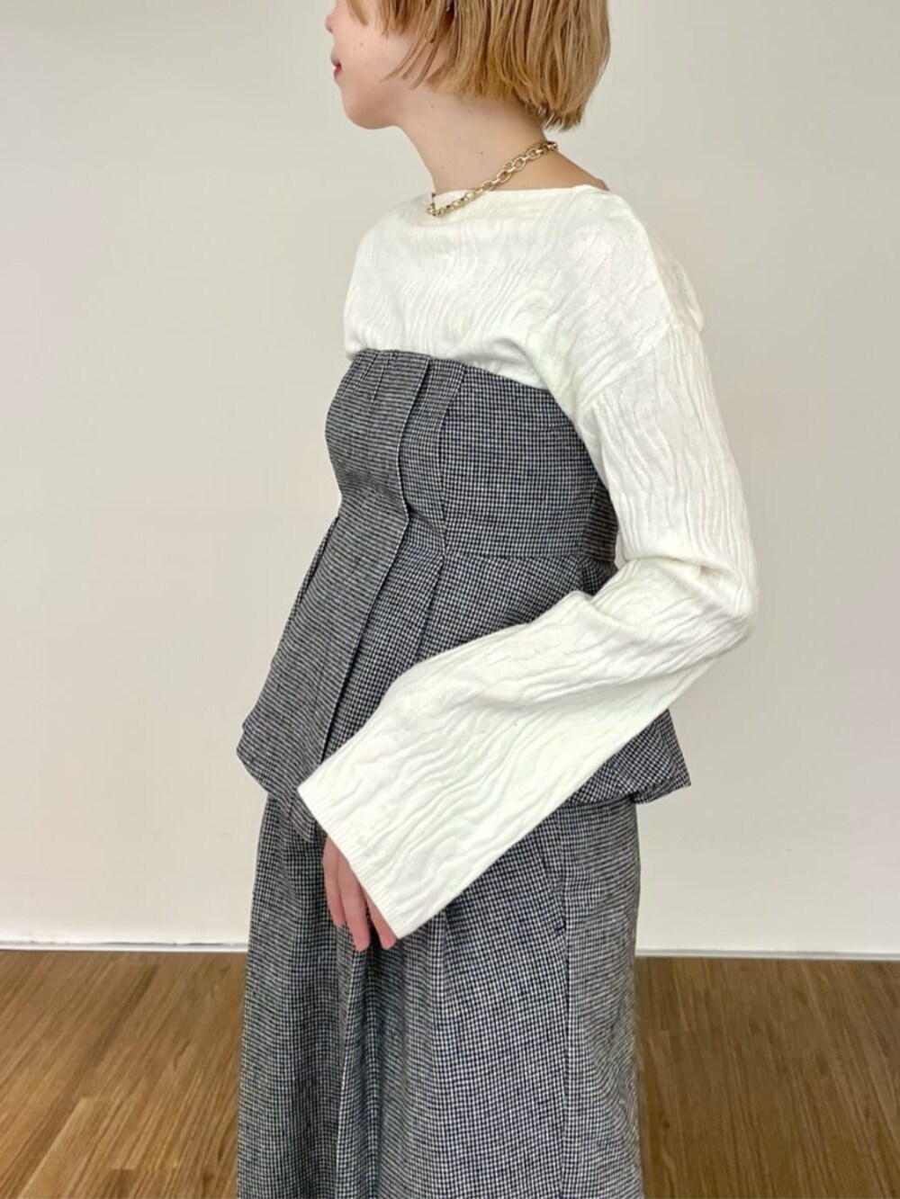 ホワイト系のニット/セーター、ブラック系のベスト、ブラック系のその他パンツを着用したレディースの冬コーディネートの4枚目の写真