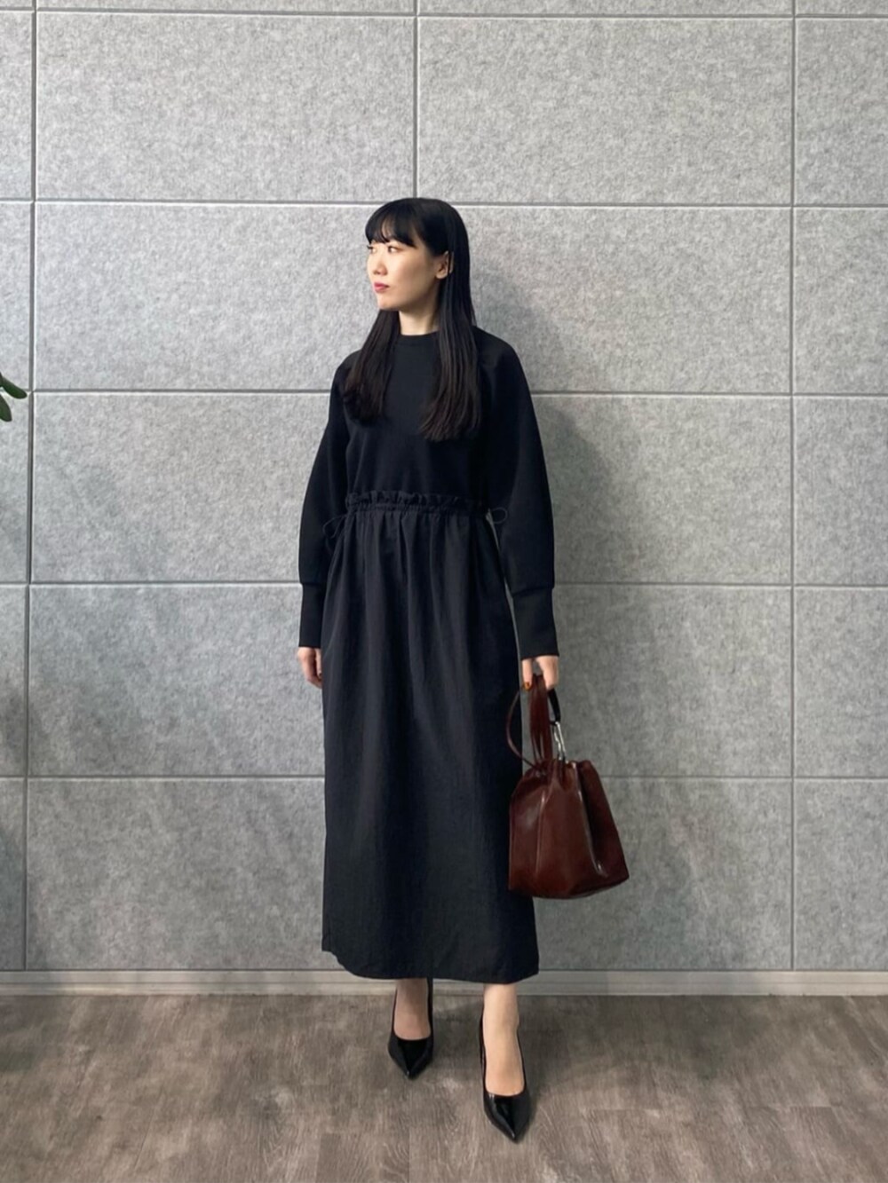 ブラック系のワンピースを着用したレディースの秋コーディネートの2枚目の写真