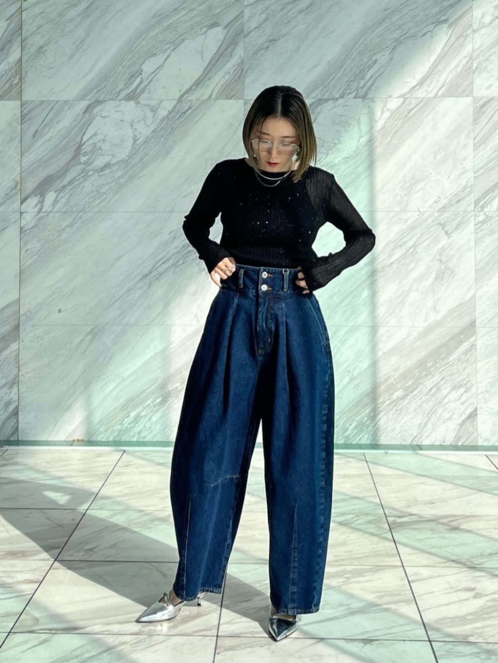 ブルー系のデニムパンツ、ブラック系のニット/セーターを着用したレディースの冬コーディネートの5枚目の写真