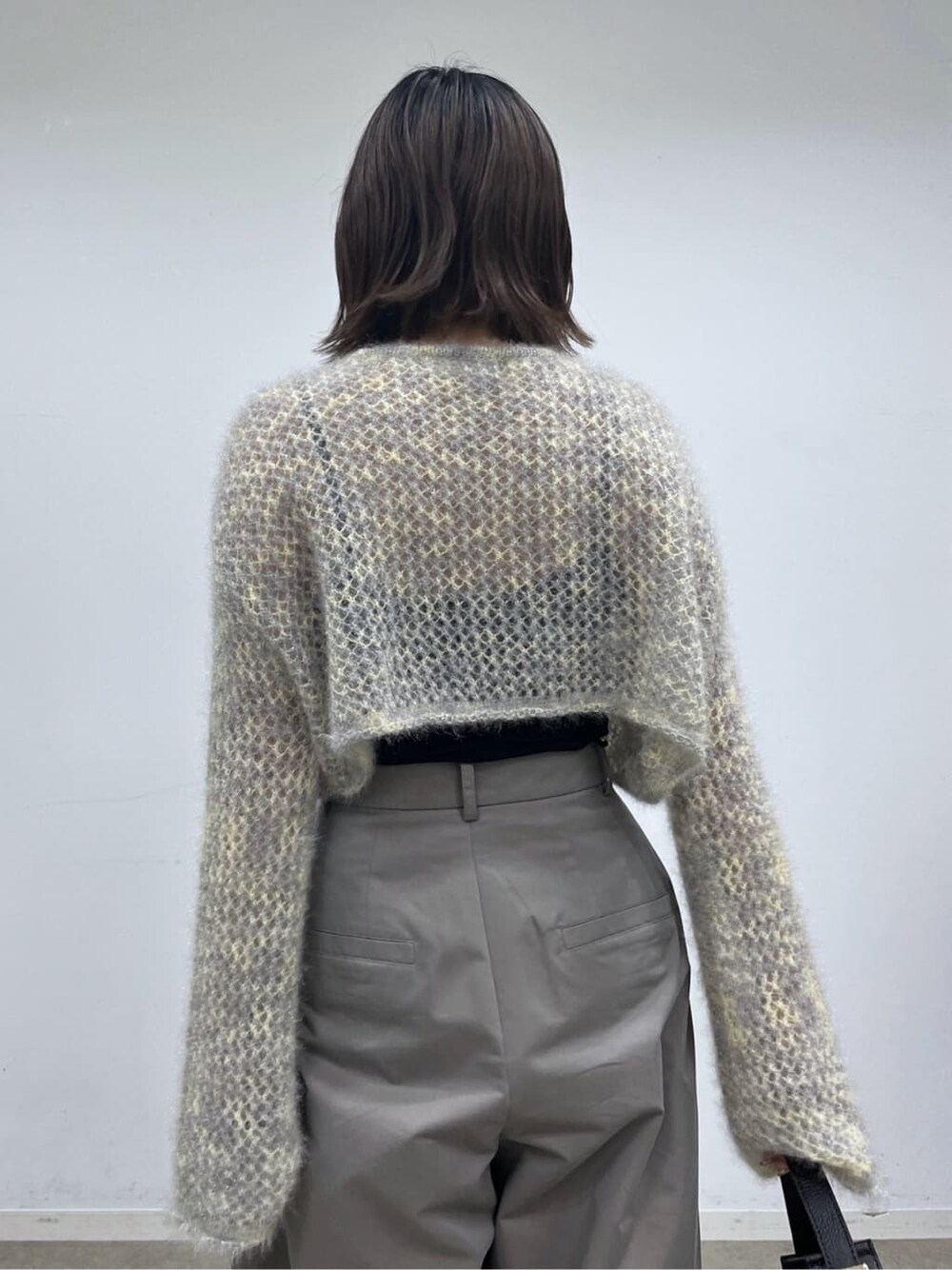 ベージュ系のニット/セーター、グレー系のその他パンツ、ブラック系のショルダーバッグを着用したレディースの冬コーディネートの8枚目の写真