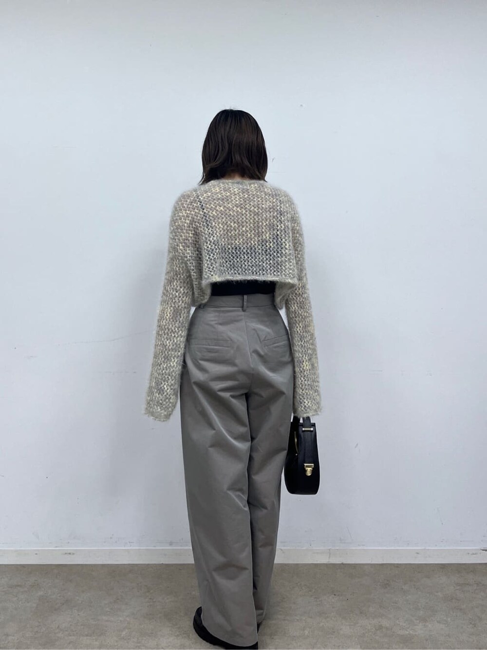 ベージュ系のニット/セーター、グレー系のその他パンツ、ブラック系のショルダーバッグを着用したレディースの冬コーディネートの4枚目の写真
