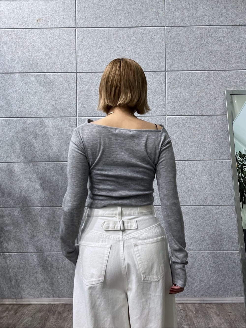 グレー系のTシャツ/カットソー、ホワイト系のデニムパンツを着用したレディースの冬コーディネートの9枚目の写真