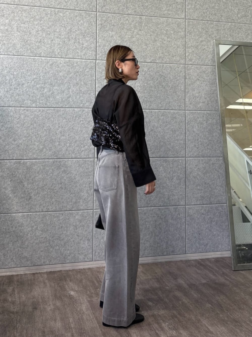 グレー系のデニムパンツ、ブラック系のタンクトップ、ブラック系のシャツ/ブラウスを着用したレディースの春コーディネートの3枚目の写真