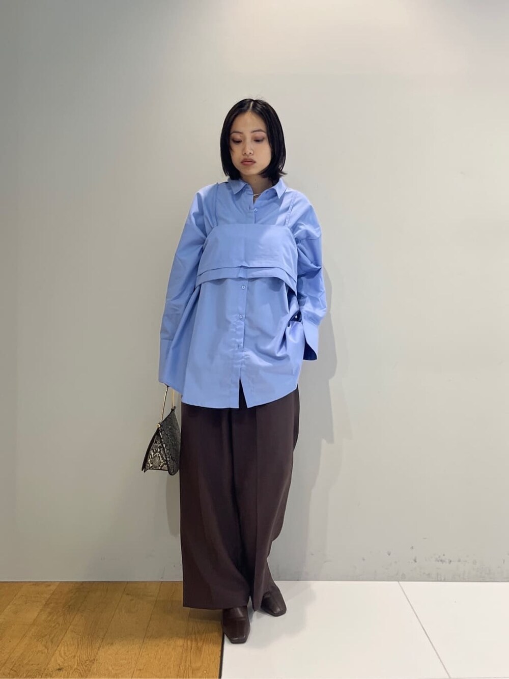 ブルー系のシャツ/ブラウス、ブラウン系のその他パンツ、グレー系のショルダーバッグを着用したレディースの秋コーディネートの6枚目の写真