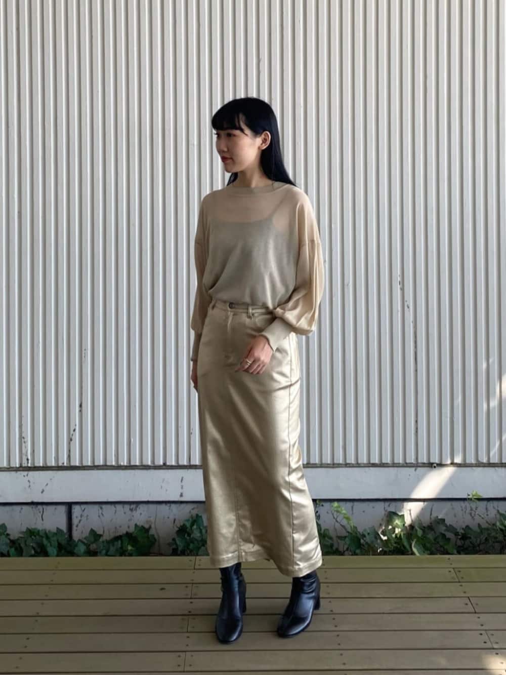 ブラック系のブルゾン、ゴールド系のスカート、ベージュ系のニット/セーターを着用したレディースの秋コーディネートの3枚目の写真