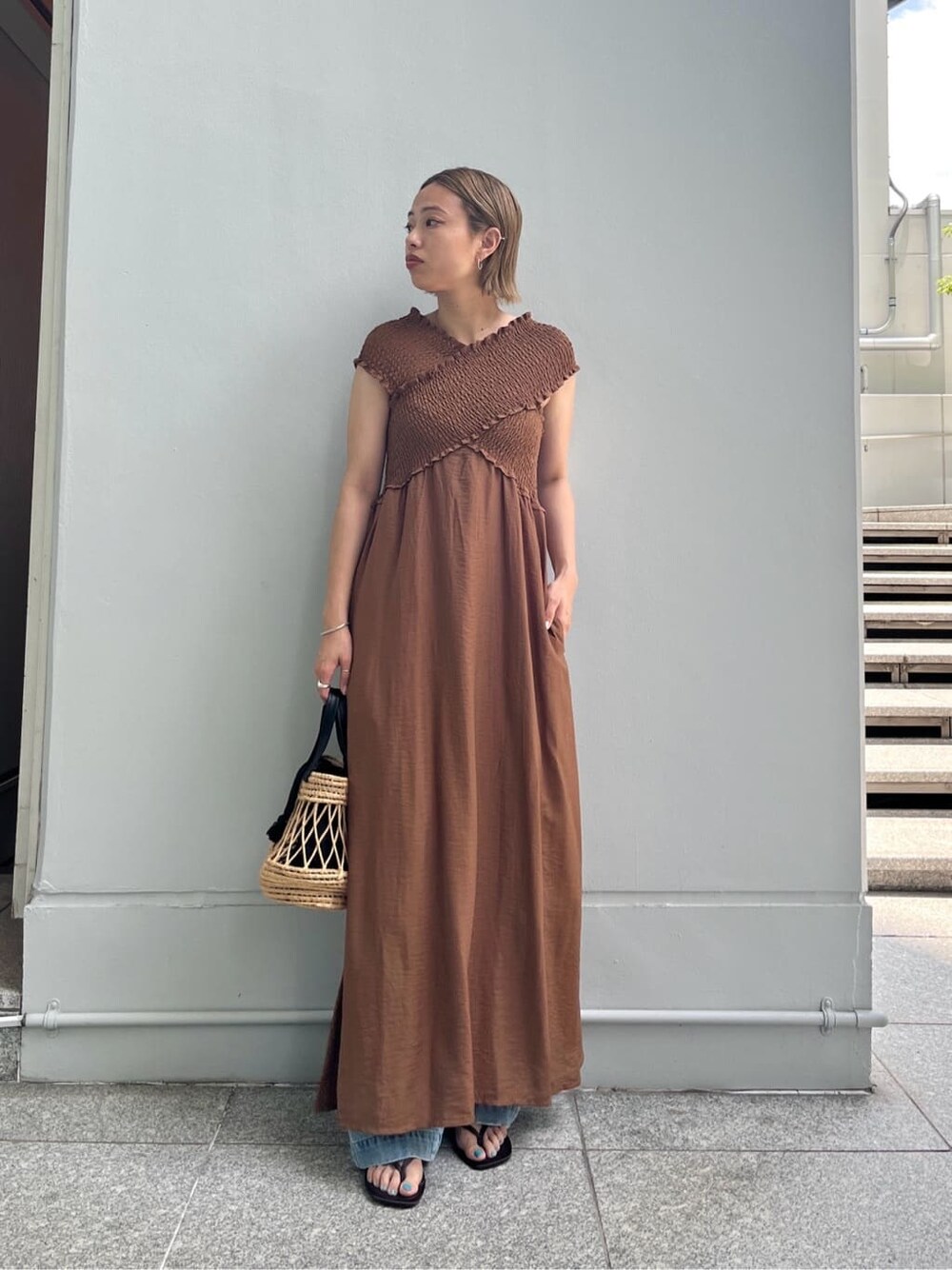 ブラウン系のワンピース、ブルー系のデニムパンツ、ブラック系のハンドバッグを着用したレディースの夏コーディネートの8枚目の写真