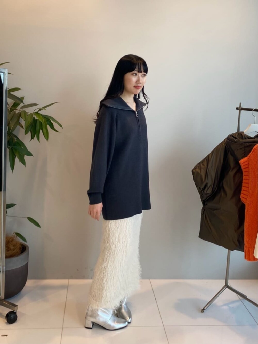 グレー系のニット/セーター、ホワイト系のスカートを着用したレディースの冬コーディネートの3枚目の写真