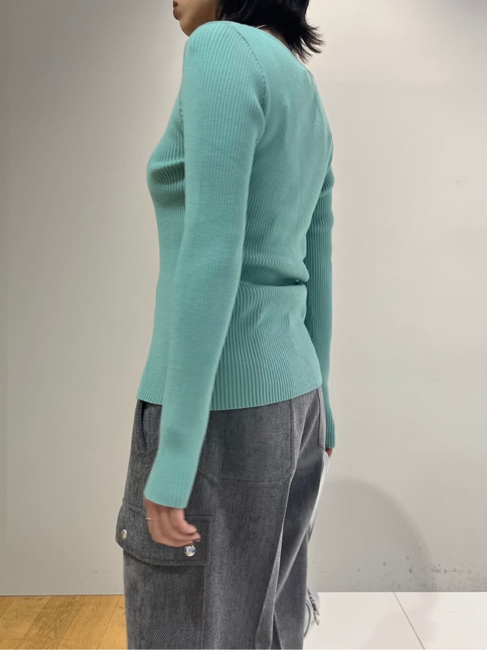 グリーン系のニット/セーター、グレー系のその他パンツ、シルバー系のハンドバッグを着用したレディースの秋コーディネートの5枚目の写真