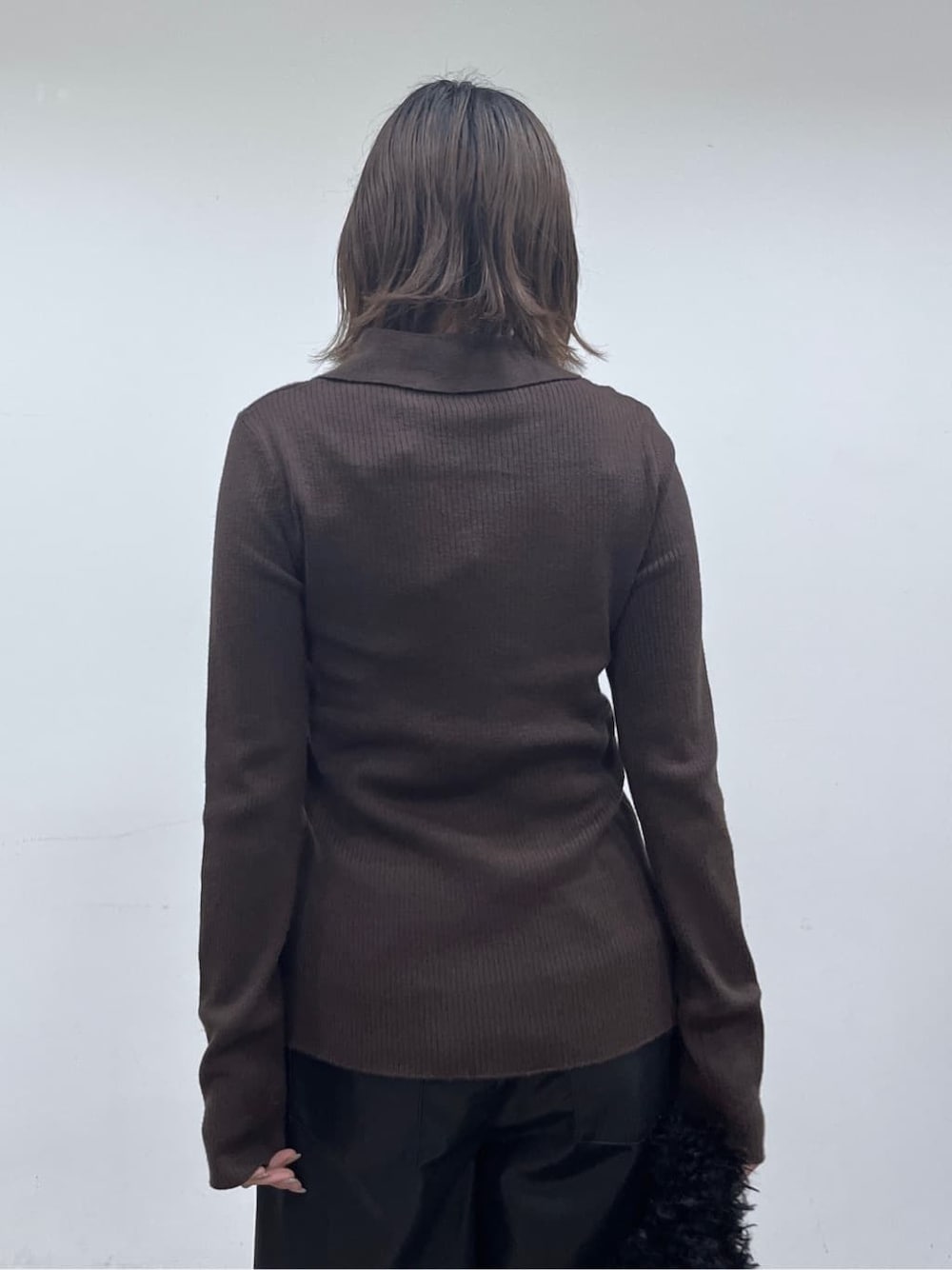 ブラウン系のニット/セーター、ブラック系のその他パンツ、ブラック系のブーツを着用したレディースの秋コーディネートの9枚目の写真