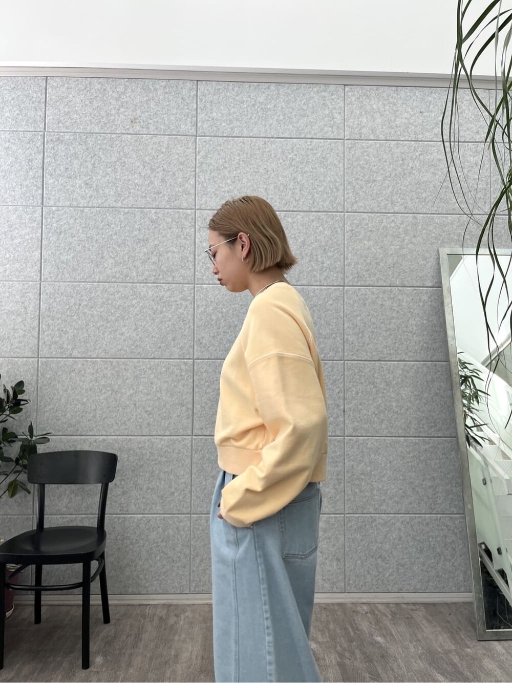 オレンジ系のスウェット、ブルー系のデニムパンツを着用したレディースの春コーディネートの7枚目の写真