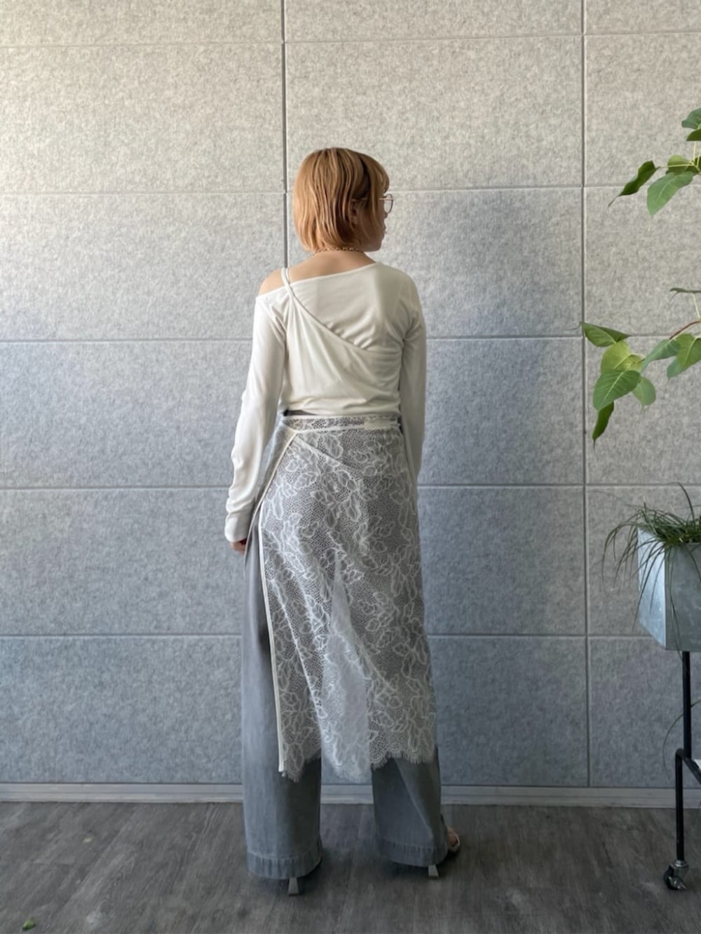 グレー系のデニムパンツ、ホワイト系のTシャツ/カットソー、ホワイト系のスカートを着用したレディースの春コーディネートの3枚目の写真
