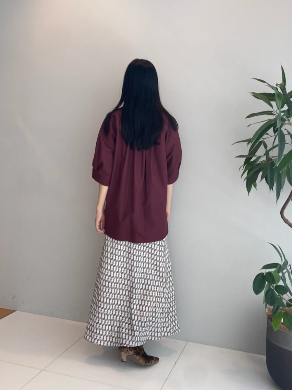 ベージュ系のスカート、レッド系のシャツ/ブラウス、ブラウン系のブーツを着用したレディースの秋コーディネートの2枚目の写真