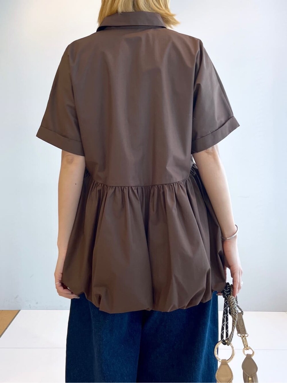 ブラウン系のシャツ/ブラウス、ブルー系のデニムパンツを着用したレディースの春コーディネートの6枚目の写真