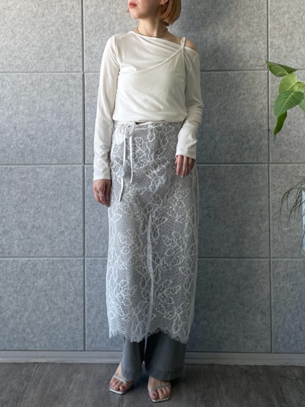 グレー系のデニムパンツ、ホワイト系のTシャツ/カットソー、ホワイト系のスカートを着用したレディースの春コーディネートの4枚目の写真