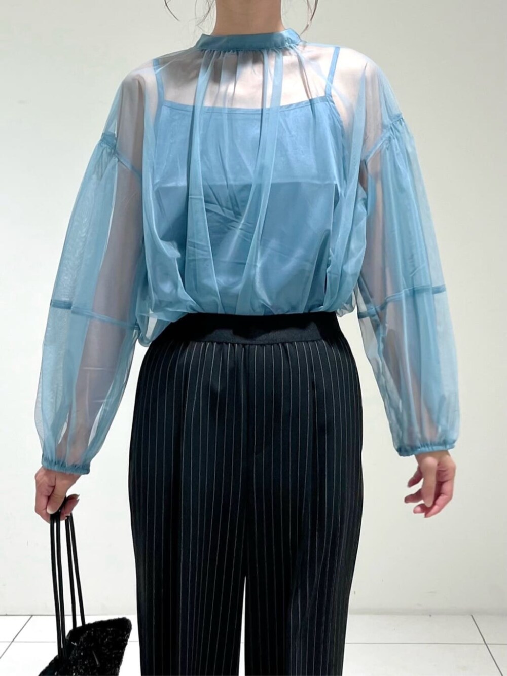 ブラック系のトートバッグ、ブルー系のシャツ/ブラウス、ブラック系のその他パンツを着用したレディースの秋コーディネートの4枚目の写真