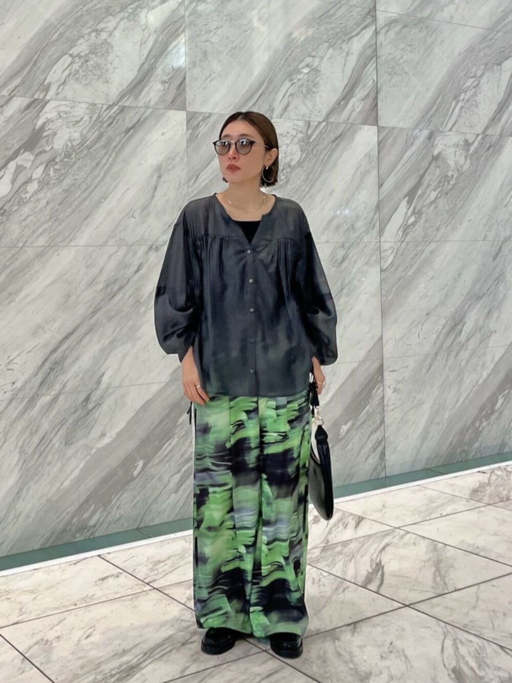 グレー系のシャツ/ブラウス、グリーン系のその他パンツを着用したレディースの春コーディネートの2枚目の写真