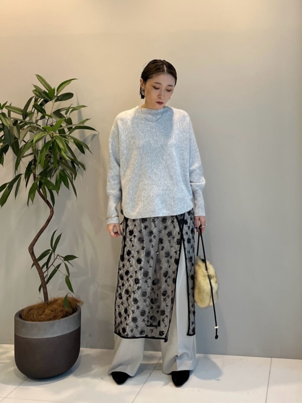 ベージュ系のその他パンツ、ブラック系のスカート、グレー系のニット/セーターを着用したレディースの冬コーディネートの3枚目の写真