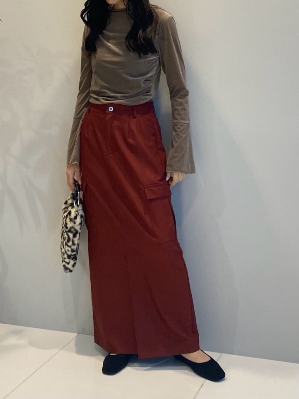 ブラウン系のハンドバッグ、レッド系のスカート、ベージュ系のTシャツ/カットソーを着用したレディースの秋コーディネートの3枚目の写真