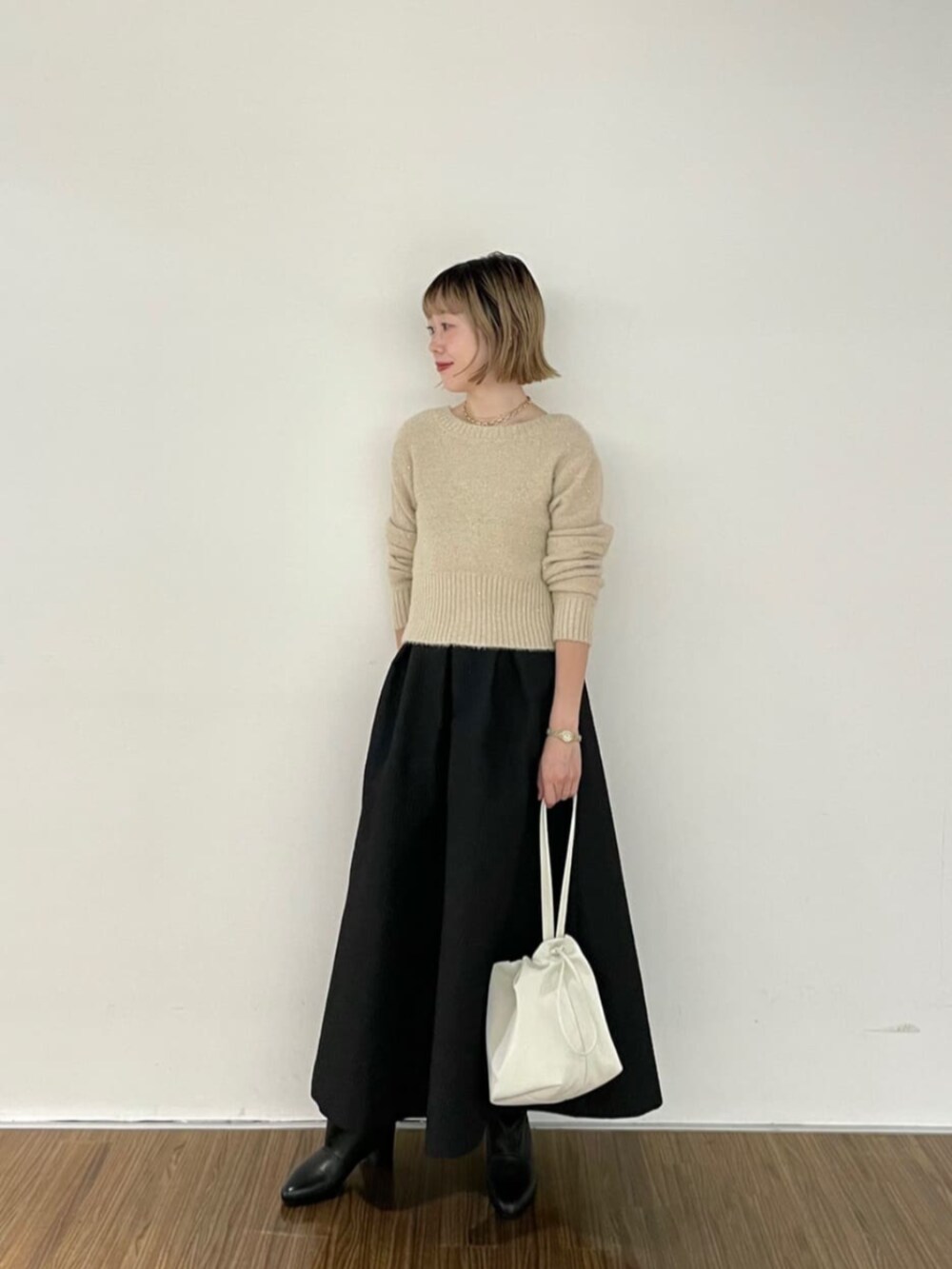 ベージュ系のカーディガン/ボレロ、ブラック系のブーツ、ブラック系のスカートを着用したレディースの秋コーディネートの3枚目の写真