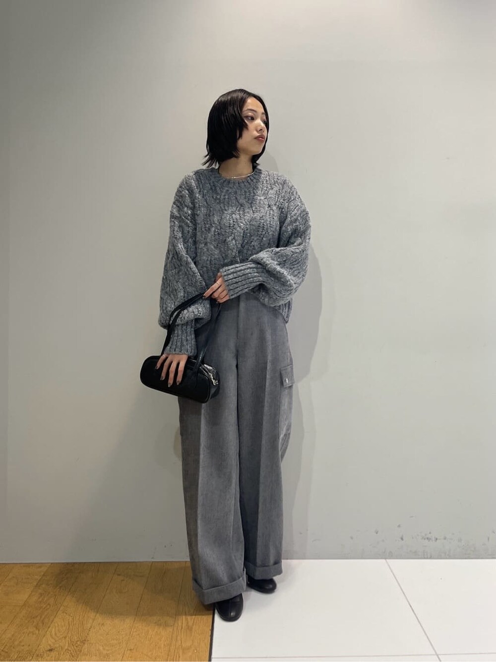 グレー系のニット/セーター、グレー系のその他パンツ、ブラック系のハンドバッグを着用したレディースの秋コーディネートの7枚目の写真