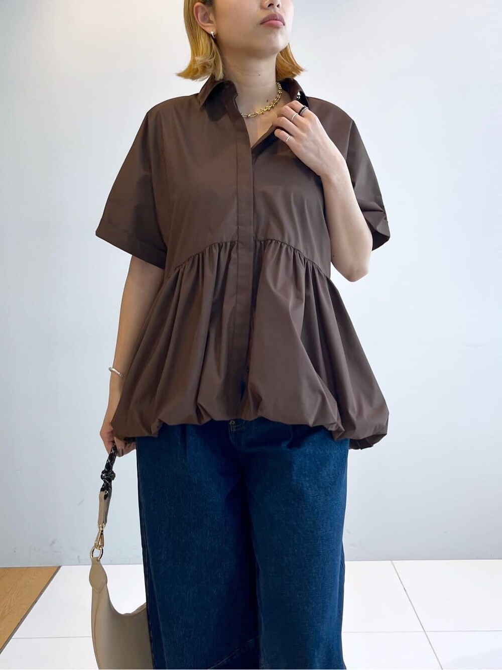 ブラウン系のシャツ/ブラウス、ブルー系のデニムパンツを着用したレディースの春コーディネートの4枚目の写真